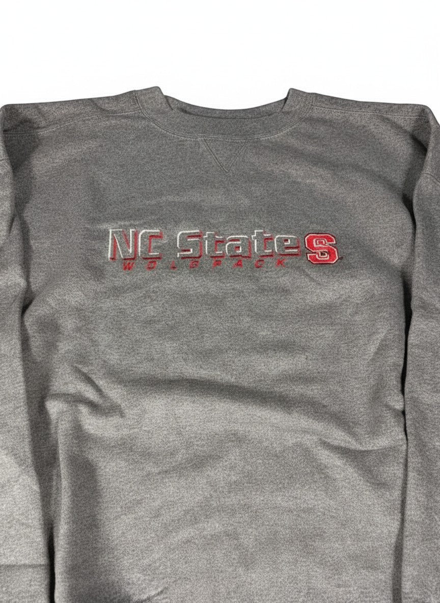 Throwback Rack grey crewneck sweatshirt with embroidered NC State Wolfpack logo. Vintage athletic apparel.
