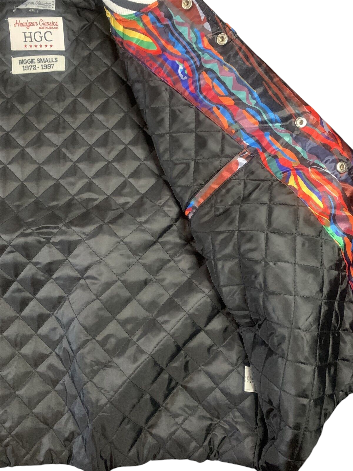 Throwback Rack Biggie Smalls varsity jacket interior featuring black quilted lining and vibrant abstract print trim.