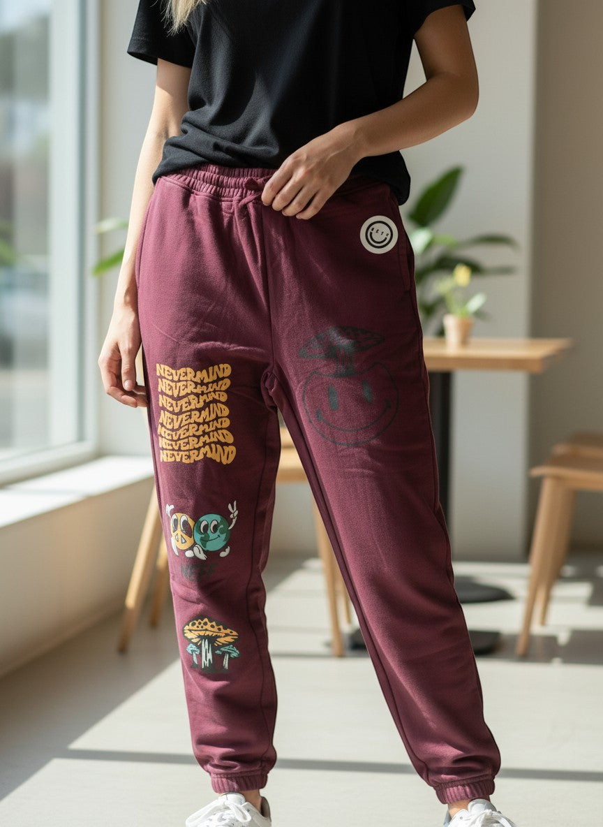 Throwback Rack burgundy sweatpants with "Nevermind" text graphic and cartoon graphics of a mushroom, earth, and peace sign.