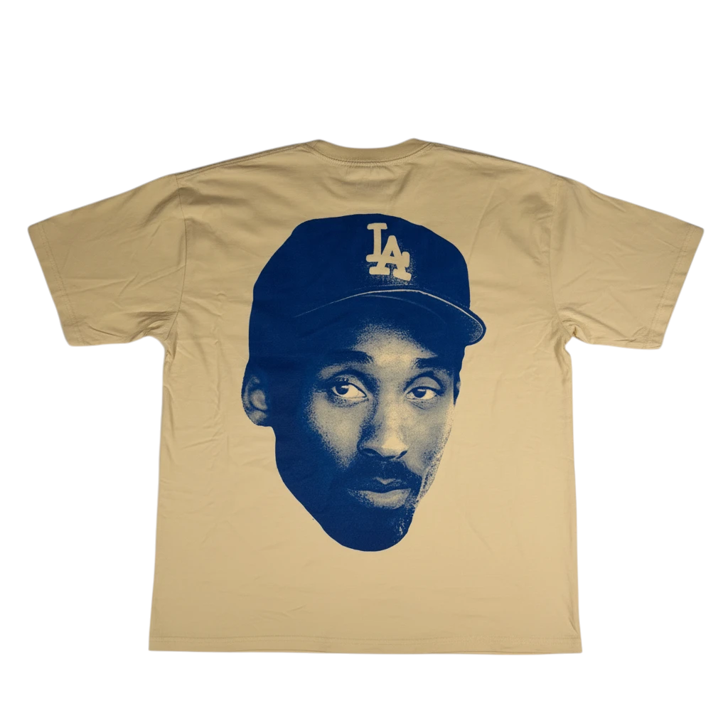 Throwback Rack tan t-shirt featuring a blue graphic of Kobe Bryant wearing a Los Angeles Dodgers baseball cap.