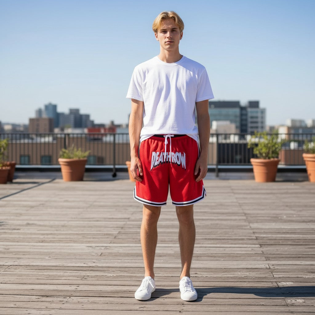 Throwback Rack red mesh basketball shorts with white drawstring and "DEATH ROW" logo. Model is wearing a white t-shirt and white sneakers.
