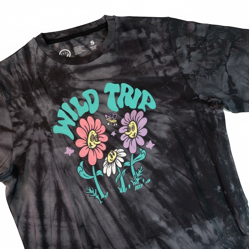 Throwback Rack black tie-dye t-shirt with a graphic of "Wild Trip" text, smiling flowers, and a bee. Made of cotton.
