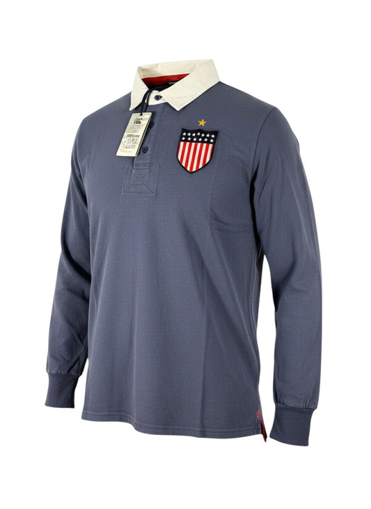 Throwback Rack USA Canterbury blue long-sleeve rugby polo shirt with white collar and US flag shield patch on chest.