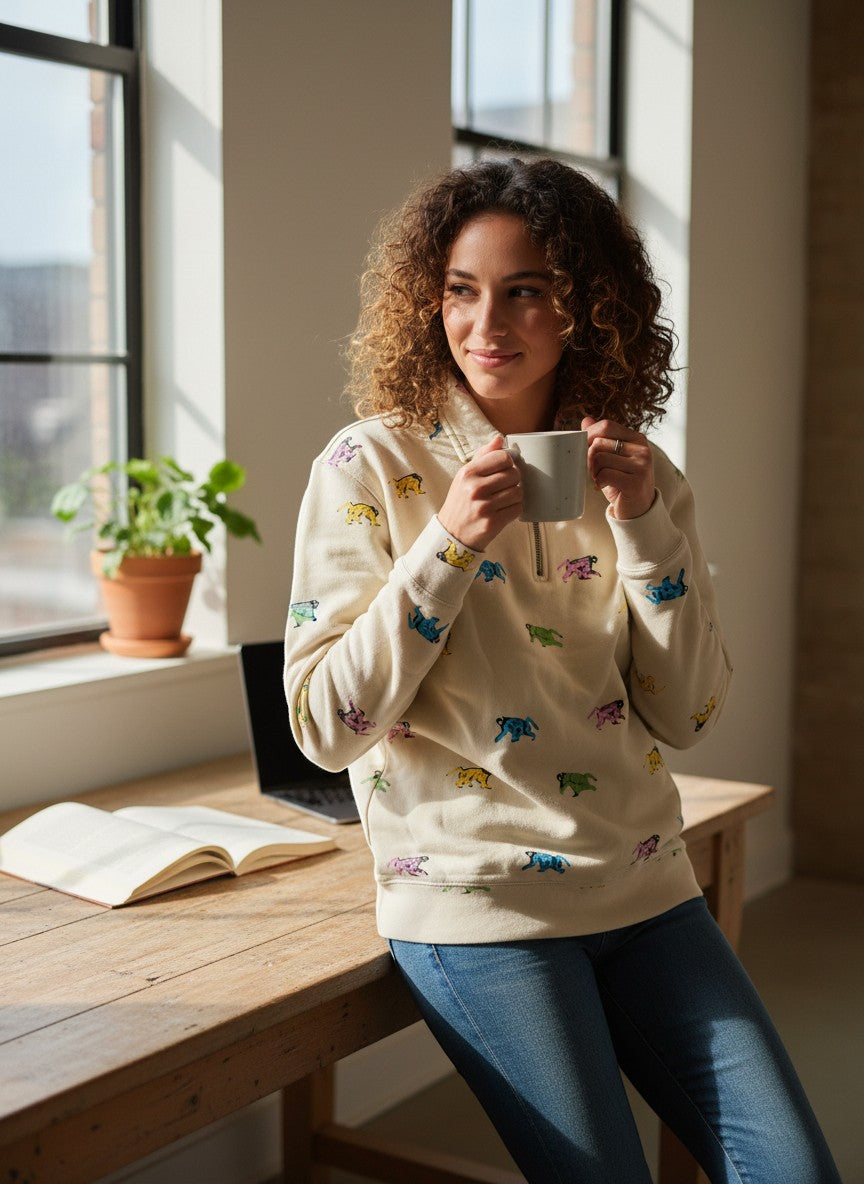 Throwback Rack x Levi's cream 1/4 zip sweatshirt with colorful graphic print. Model wears jeans and holds a mug.